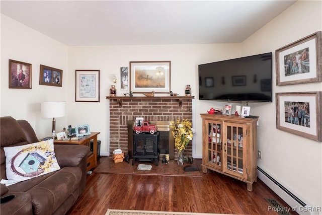 living area featuring wood finished floors, a wood stove, and a baseboard radiator