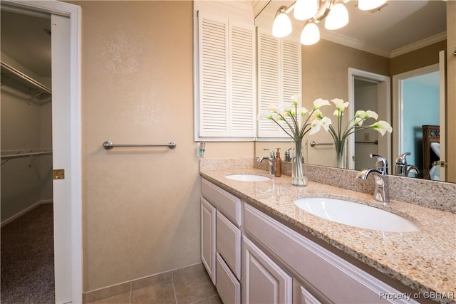 bathroom with tile patterned floors, ornamental molding, double vanity, and a sink