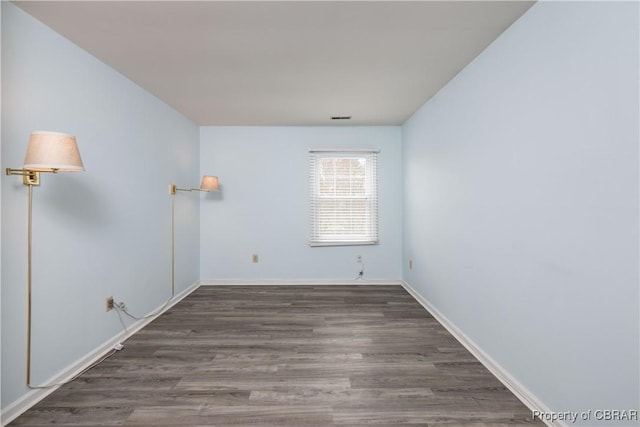 unfurnished room with visible vents, baseboards, and wood finished floors