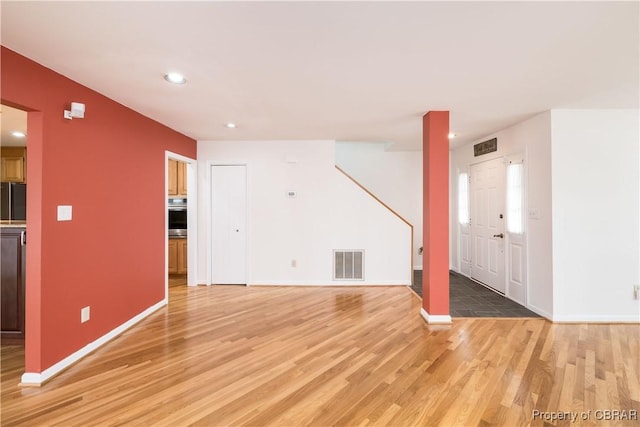 unfurnished living room with recessed lighting, visible vents, baseboards, and light wood-style flooring