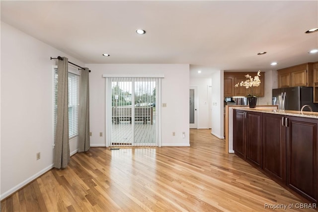 kitchen with recessed lighting, baseboards, freestanding refrigerator, and light wood-style floors