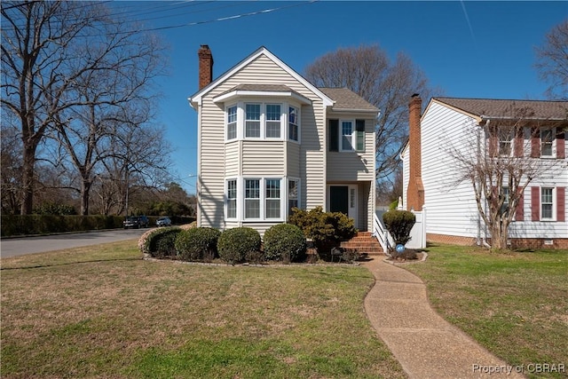 traditional home featuring a front yard and a chimney