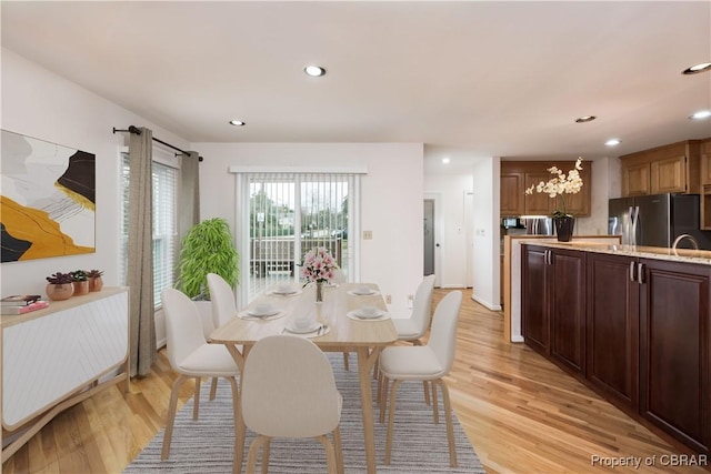 dining space with light wood finished floors and recessed lighting