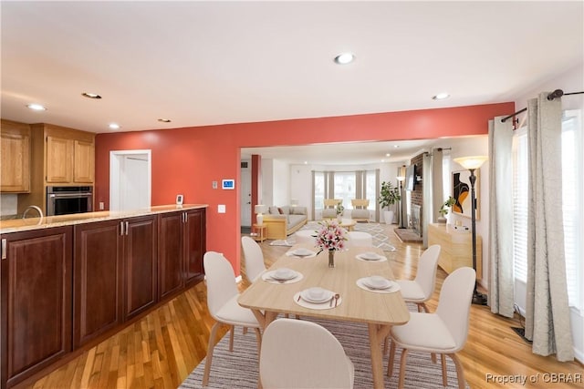 dining space with recessed lighting and light wood-style flooring