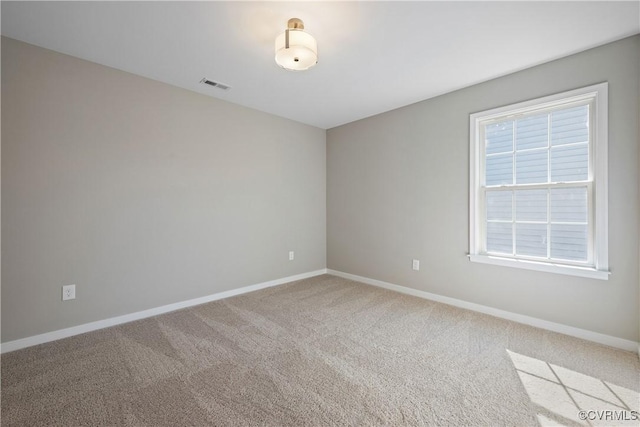 carpeted empty room featuring visible vents and baseboards