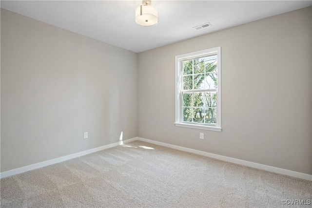 spare room with light carpet, visible vents, and baseboards