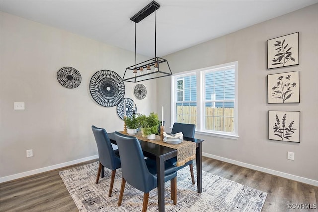 dining room with an inviting chandelier, baseboards, and wood finished floors