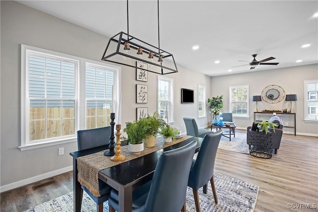 dining area with recessed lighting, ceiling fan with notable chandelier, baseboards, and wood finished floors