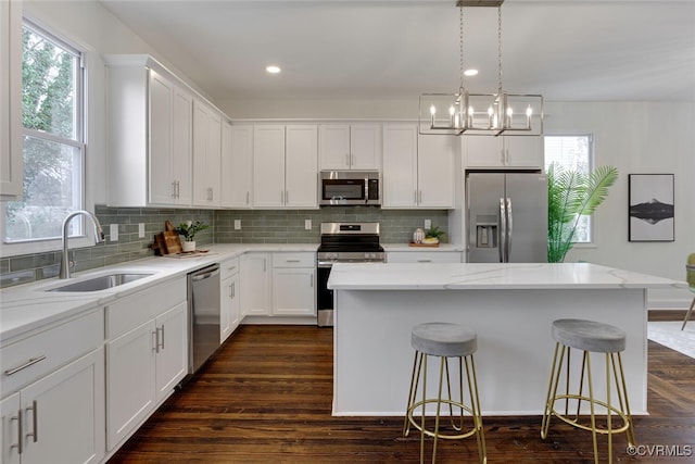 kitchen with backsplash, dark wood-style flooring, appliances with stainless steel finishes, and a sink