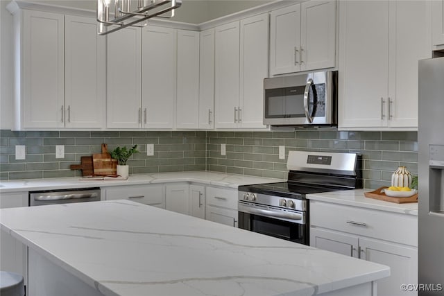 kitchen with light stone counters, backsplash, appliances with stainless steel finishes, and white cabinets