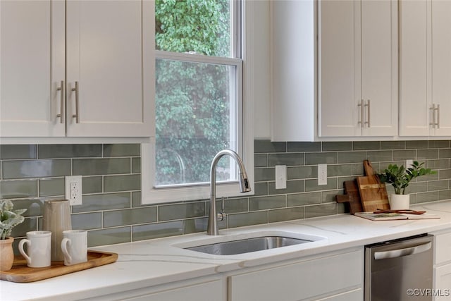 kitchen with dishwasher, white cabinets, plenty of natural light, and a sink