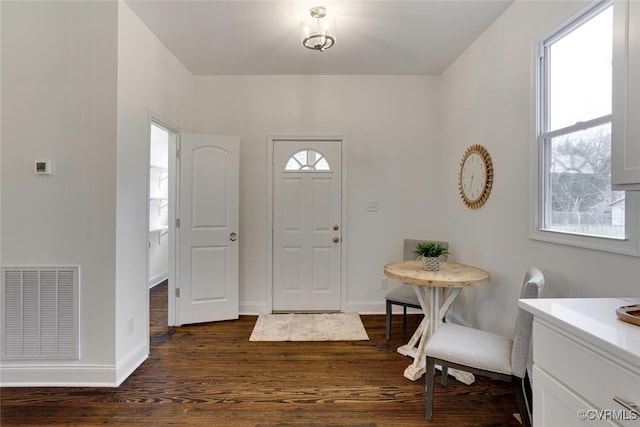 foyer with visible vents, baseboards, and dark wood-style flooring