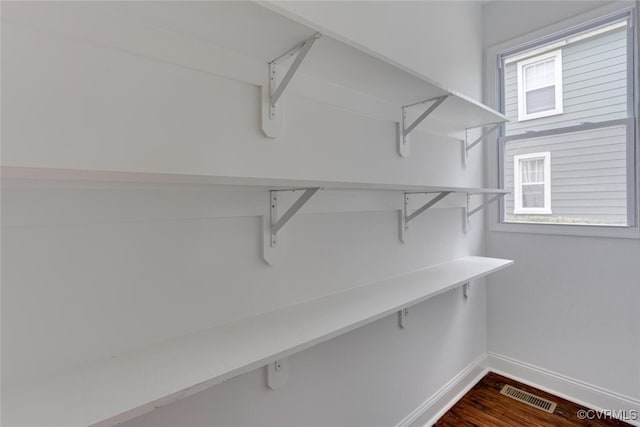 walk in closet featuring visible vents and dark wood-style flooring