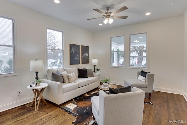 living room featuring recessed lighting, dark wood-type flooring, and baseboards