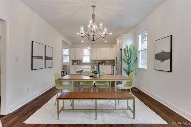 dining space with a notable chandelier, dark wood-style floors, and baseboards