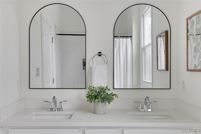 bathroom featuring a sink and double vanity