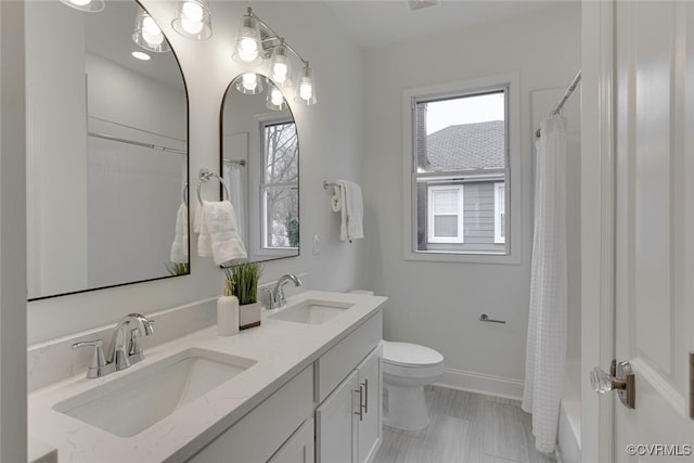 bathroom with a healthy amount of sunlight, toilet, and a sink