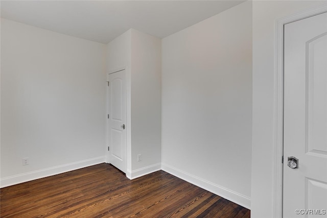 empty room with baseboards and dark wood-style flooring