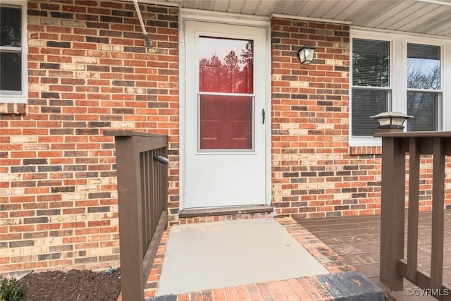 entrance to property featuring brick siding