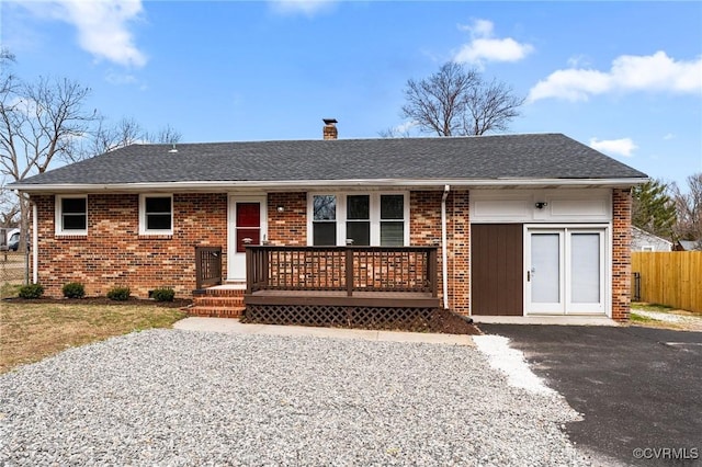 ranch-style home featuring fence, brick siding, roof with shingles, and a chimney