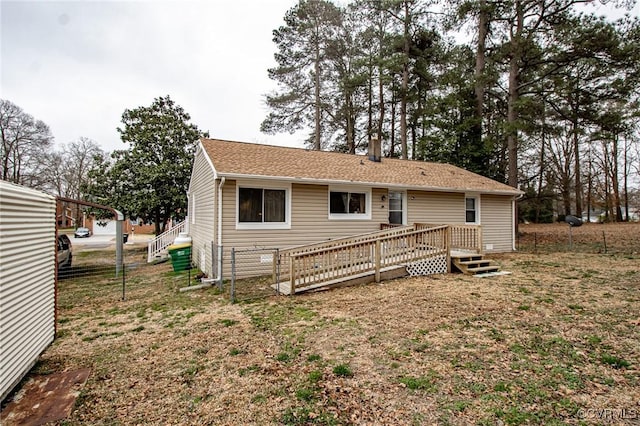 rear view of property featuring a wooden deck and a shingled roof