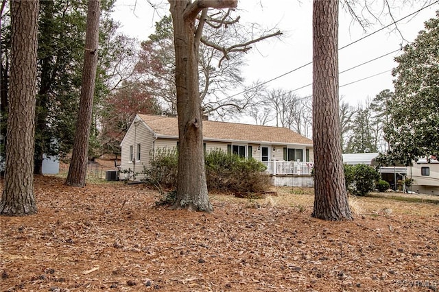 ranch-style house featuring central AC unit and roof with shingles