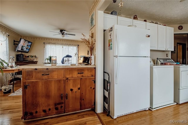 kitchen featuring light wood-type flooring, independent washer and dryer, ceiling fan, and freestanding refrigerator