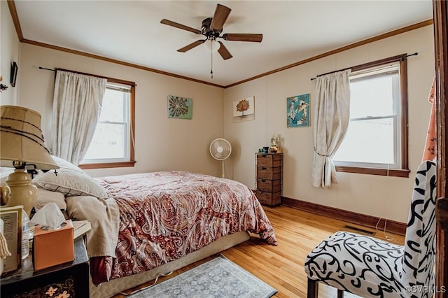 bedroom featuring visible vents, crown molding, ceiling fan, baseboards, and wood finished floors