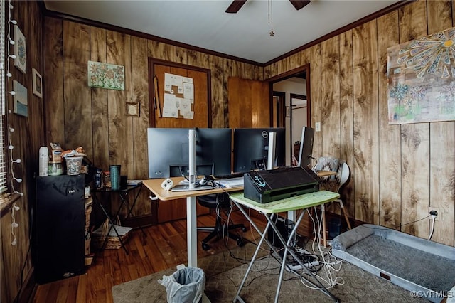 office area with wood walls, crown molding, ceiling fan, and wood finished floors