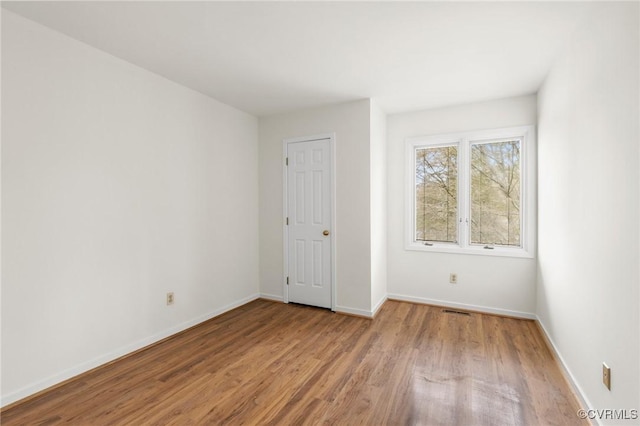 unfurnished room with visible vents, baseboards, and light wood-type flooring