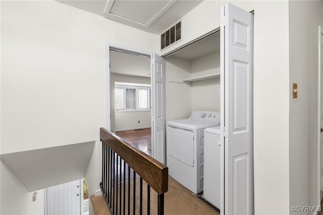 clothes washing area with laundry area, visible vents, and washing machine and clothes dryer