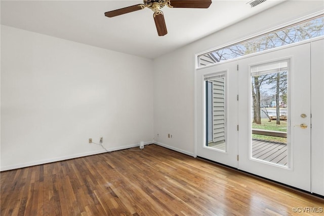 unfurnished room featuring baseboards, ceiling fan, and wood finished floors