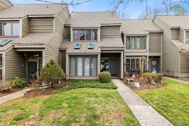 view of front of home with a front lawn and roof with shingles