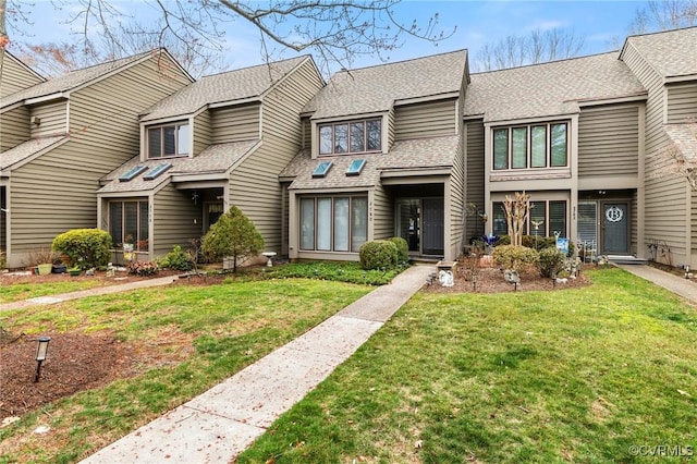 multi unit property featuring roof with shingles and a front lawn