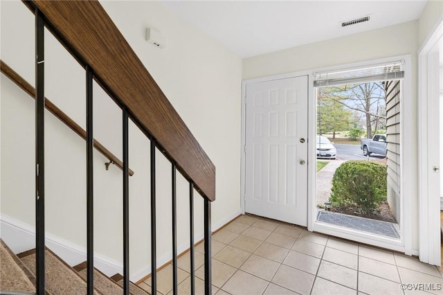 entrance foyer featuring light tile patterned floors, visible vents, and baseboards