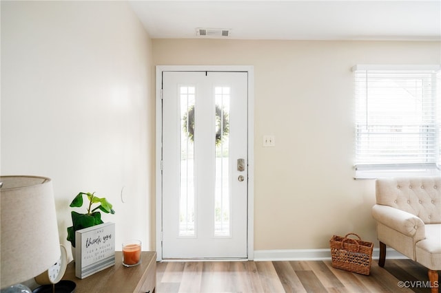 entrance foyer featuring visible vents, baseboards, and wood finished floors