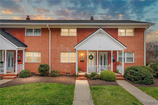 view of front of home featuring brick siding, crawl space, a porch, and a chimney