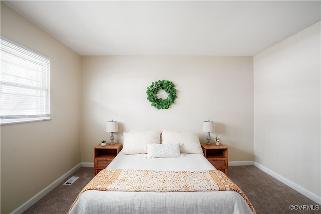 carpeted bedroom featuring visible vents and baseboards