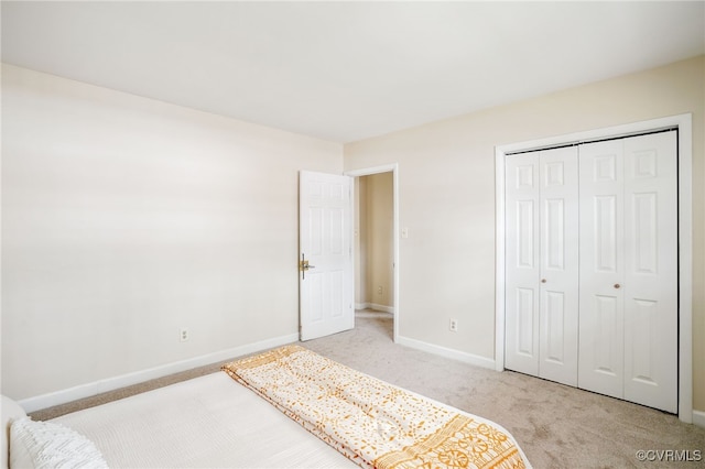 carpeted bedroom featuring a closet and baseboards