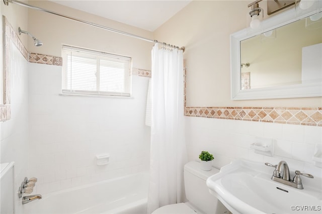 full bathroom with a sink, wainscoting, tile walls, toilet, and shower / tub combo with curtain