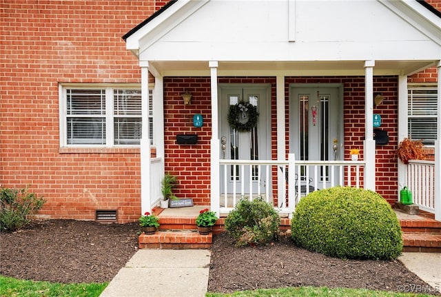 entrance to property with crawl space, covered porch, and brick siding