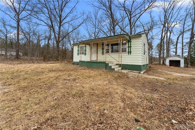 view of front of home with covered porch and an outdoor structure