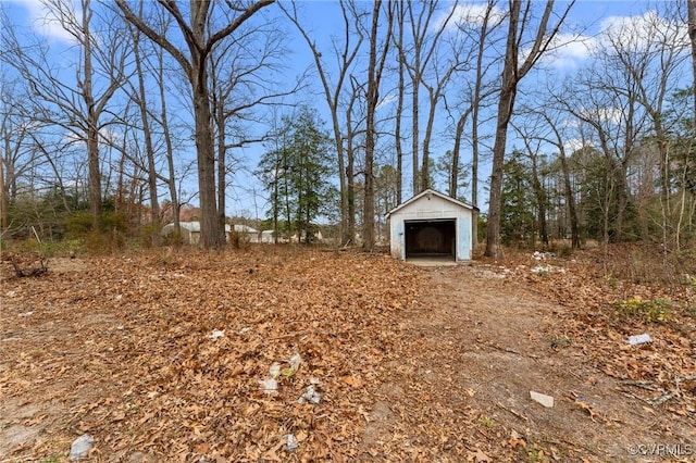 view of yard with an outdoor structure, a storage unit, and a garage