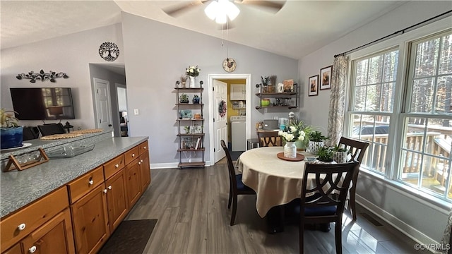 dining room with a ceiling fan, baseboards, washing machine and clothes dryer, lofted ceiling, and dark wood-style flooring