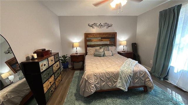 bedroom with a ceiling fan, wood finished floors, and baseboards