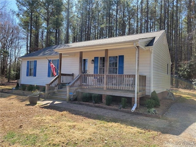 view of front of property featuring covered porch and a shingled roof