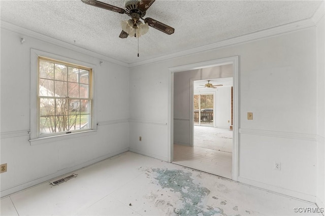 empty room with visible vents, a ceiling fan, and crown molding