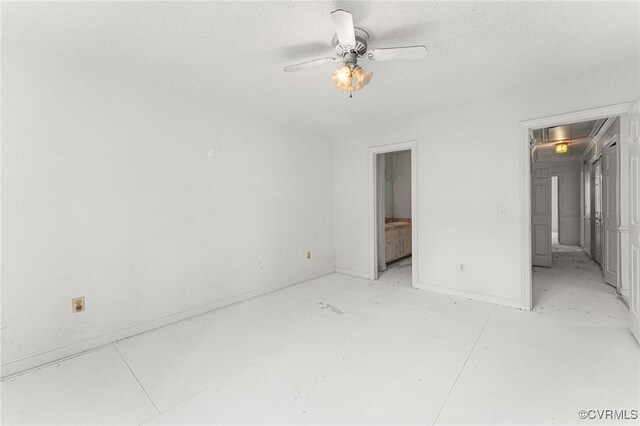 unfurnished bedroom featuring attic access, a ceiling fan, and baseboards