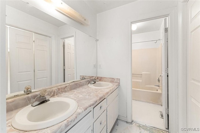 bathroom featuring a sink, shower / bathing tub combination, marble finish floor, and double vanity