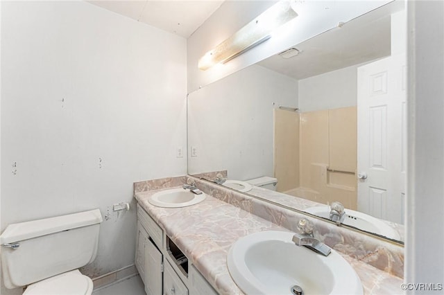 bathroom with a sink, toilet, and double vanity